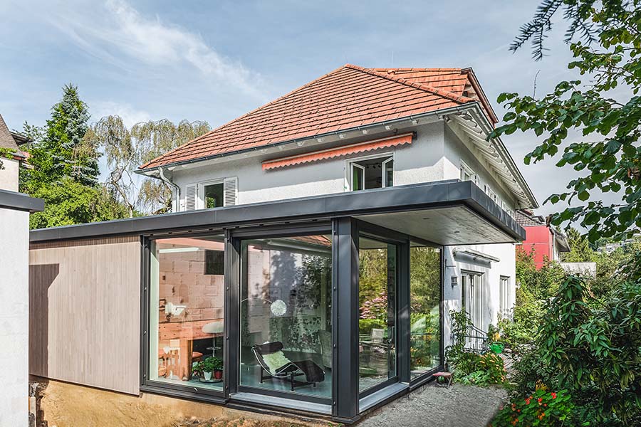 Moderner Anbau an Wohnhaus in Holzbauweise mit Holzfassade und Glasfassade