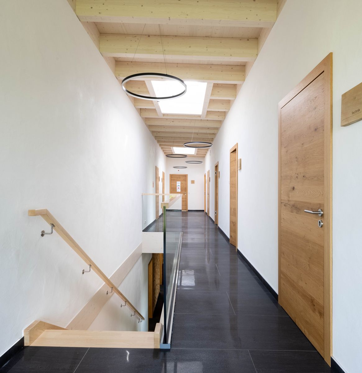 Büroflur mit sichtbarer Holzdecke und natürlichem Licht